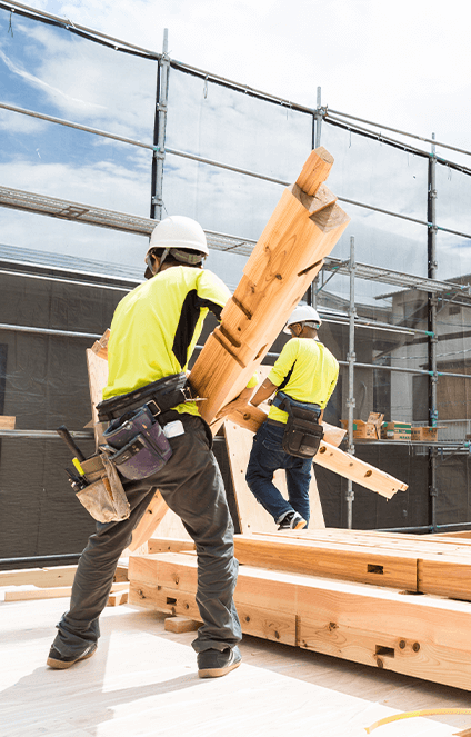施工現場で木材を抱えている男性の写真